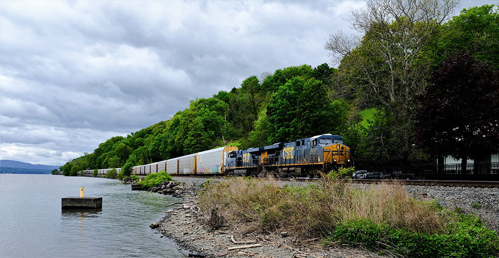 A CSX freight train hugs the west shore of the Hudson River as it passes the Milton Landing traveling north.